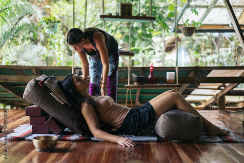 Yoga teacher practicing restorative yoga with singing bowls