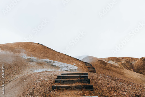Wooden stairs leading up along brown landscape of Iceland 