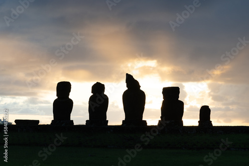 Sunset behind the moai statues on Ahu Vai Ure in Tahai complex on Easter Island (Rapa Nui) in Chile. Tahai is an archaeological complex near the village Hanga Roa. photo