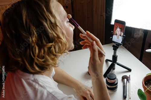 Blogger applying makeup during life stream photo