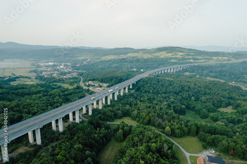 Transport bridge in mountainous area, road and trees. A panoramic view of nature from above.