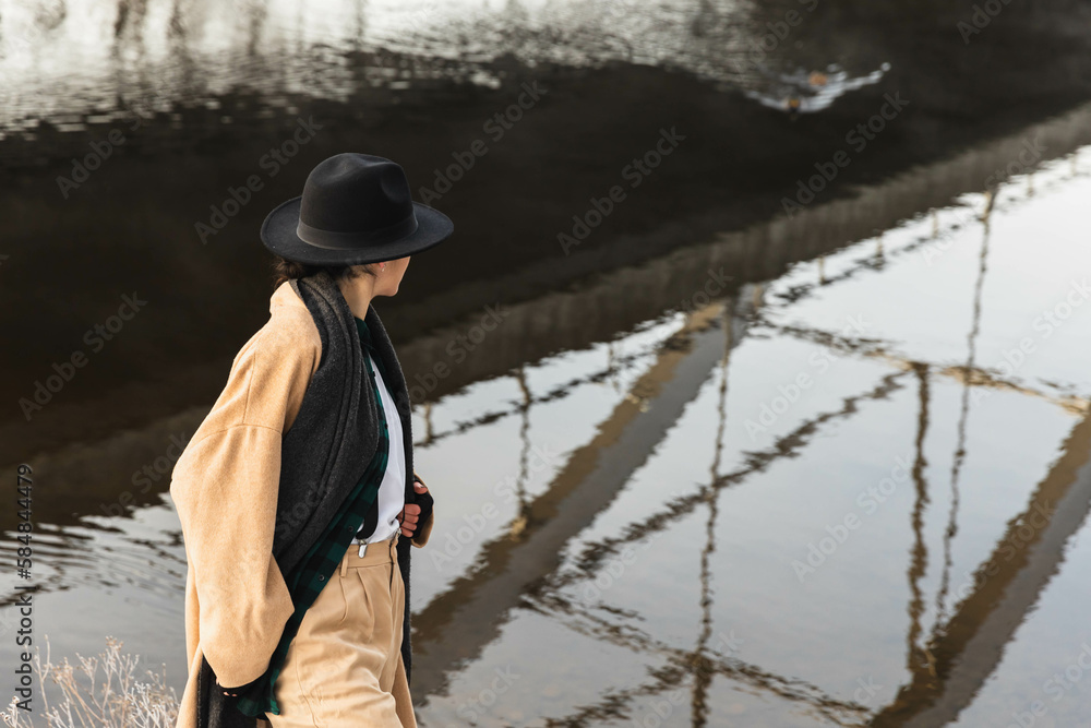 Unrecognizable stylish woman next to a river Unrecognizable stylish woman next to a river