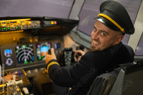 Caucasian bearded man smiling while sitting in a flight simulator. Pilot in the cockpit.