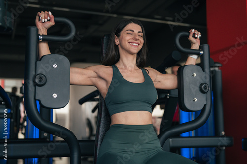 Woman exercising on chest fly machine photo