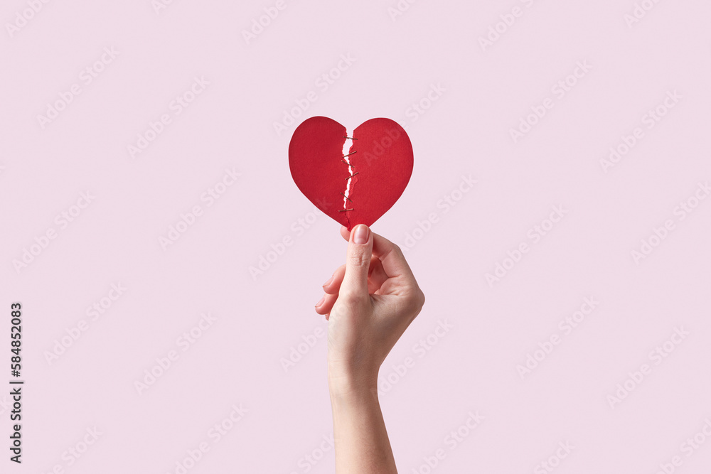 Red broken paper heart in female hand. Red broken paper heart in female hand.