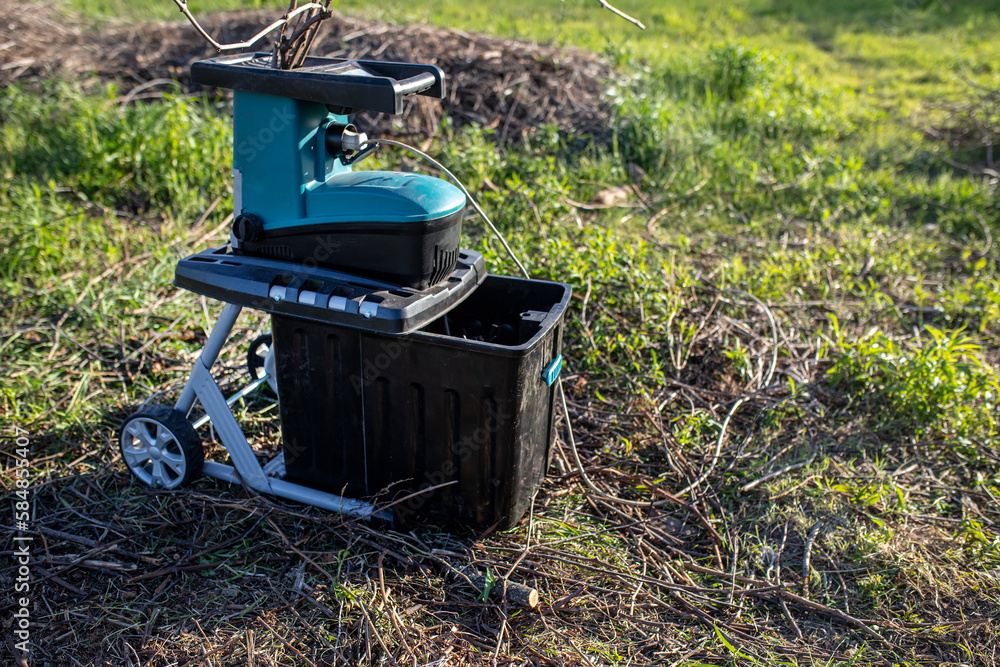 shredded branches and vines in a container electric garden grinder to shred, a tool for cutting wood waste and pruning and tidying up your garden shredded branches and vines in a container electric garden grinder to shred, a tool for cutting wood waste and pruning and tidying up your garden