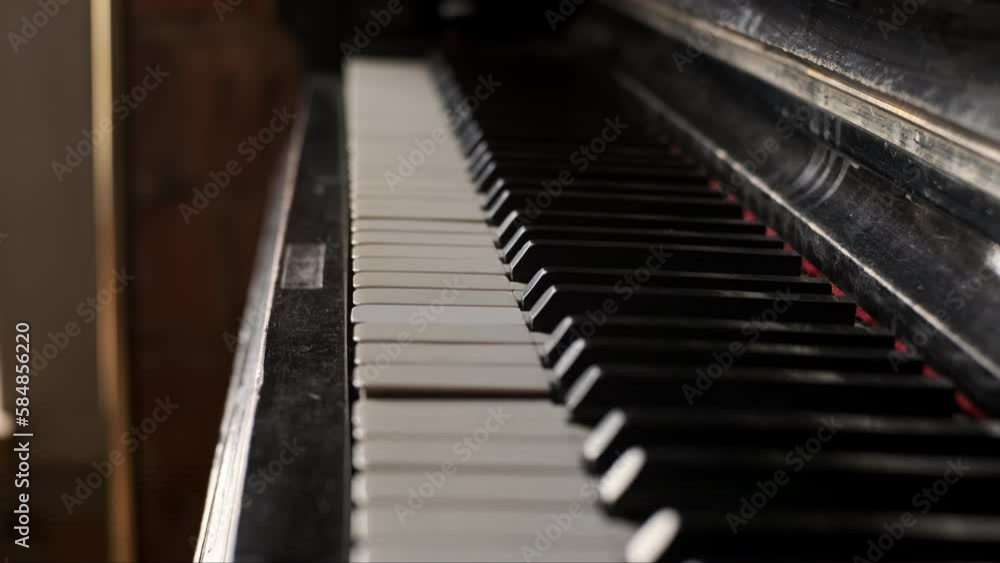 Rack focus old dusty piano close up view of yellow keys from time. Old broken keyboard musical instrument. Rack focus old dusty piano close up view of yellow keys from time. Old broken keyboard musical instrument.