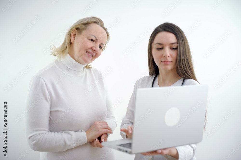 Adult doctor and young nurse with laptop on white backgrund,. High quality photo Adult doctor and young nurse with laptop on white backgrund,. High quality photo