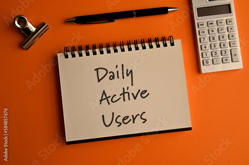 There is a notebook with the word Daily Active Users. It is eye-catching image.