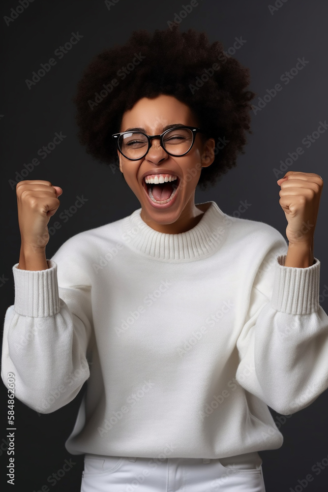 Mulher afro-americana muito feliz cerra os punhos com triunfo, ri de felicidade, regozija-se com o sucesso, usa óculos, suéter branco, torce pelo time favorito, isolado em fundo cinza Mulher afro-americana muito feliz cerra os punhos com triunfo, ri de felicidade, regozija-se com o sucesso, usa óculos, suéter branco, torce pelo time favorito, isolado em fundo cinza