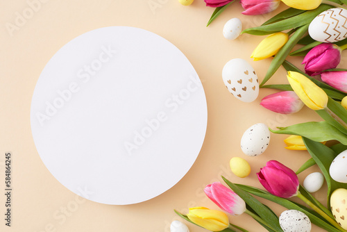 Easter mockup concept. Top view photo of white circle colorful easter eggs yellow pink tulips flowers on isolated beige background with blank space