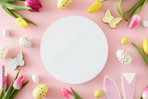 Fototapeta Naklejka Na Ścianę i Meble -  Easter idea. Top view composition of white circle colorful easter eggs rabbit bunny ears yellow pink tulips and butterfly cookies on pastel pink background with blank space