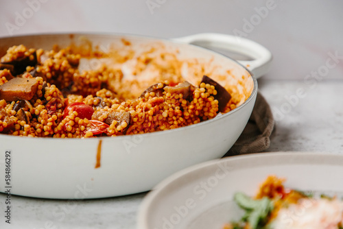 A dish of pearl couscous with tomatoes and aubergine. photo