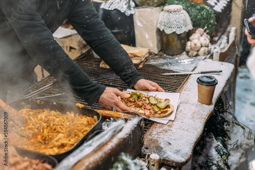 An employee of a street food store prepared a delicious sandwich photo