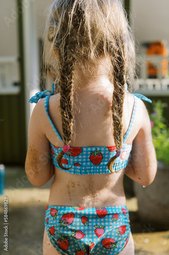 backside of toddler girl in swimsuit with fishtail braids