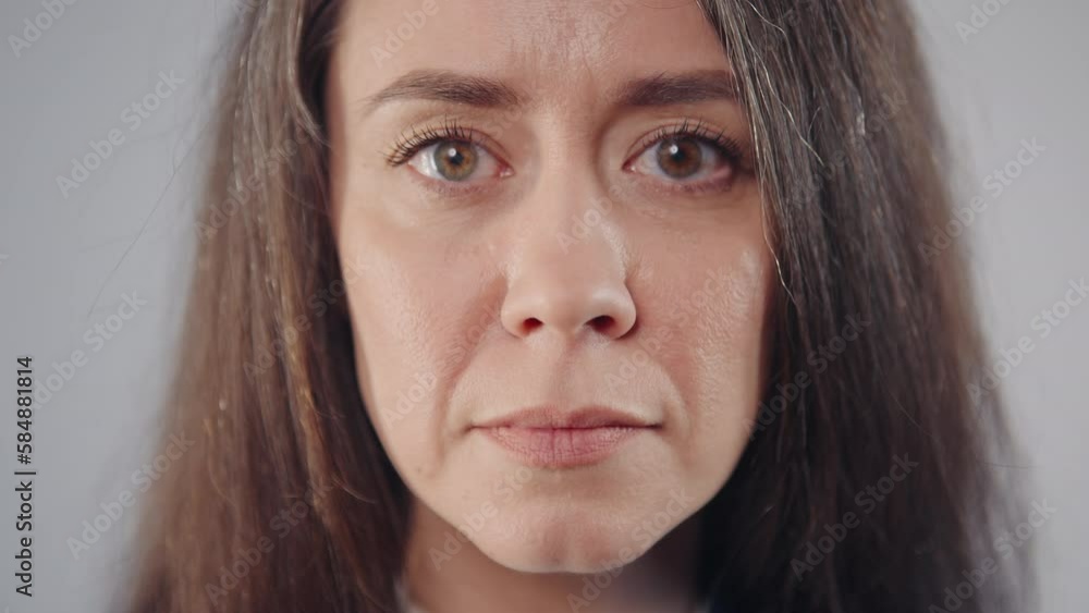 Head shot face of middle aged caucasian brunette woman standing on grey background, close-up portrait serious female office manager posing looking at camera, studio shot Head shot face of middle aged caucasian brunette woman standing on grey background, close-up portrait serious female office manager posing looking at camera, studio shot