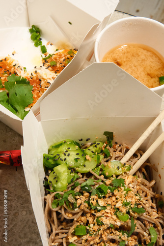 Soba noodle salad dish from food truck cart in to-go packaging. 