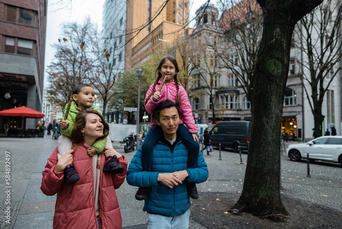 Children travel on the shoulders of their parents around the city photo