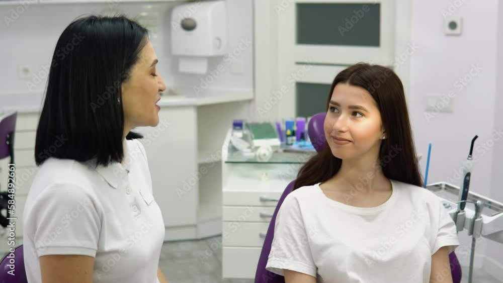 Female dentist talking to a young girl patient. Discussion of the treatment plan Female dentist talking to a young girl patient. Discussion of the treatment plan