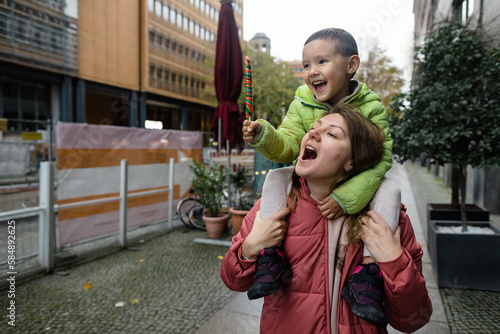 Woman and her little son playing on street photo