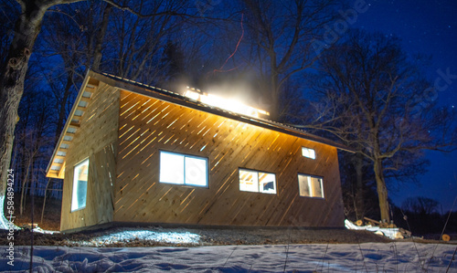 Maple sugar shack under a starry night sky, sparks coming out of the chimney, Ontario, Canada