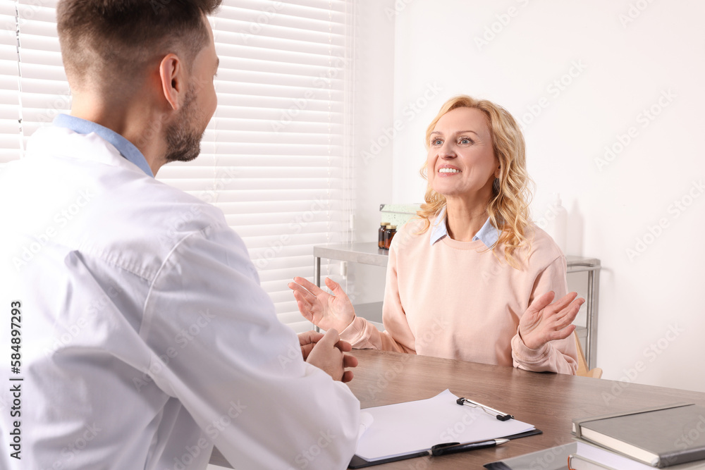 Doctor consulting patient at table in clinic Doctor consulting patient at table in clinic