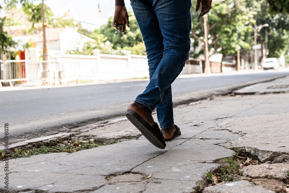 Crop unrecognizable black man walking on street Crop unrecognizable black man walking on street