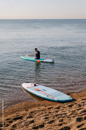 A man without legs floats on a Sup board in the early morning  photo