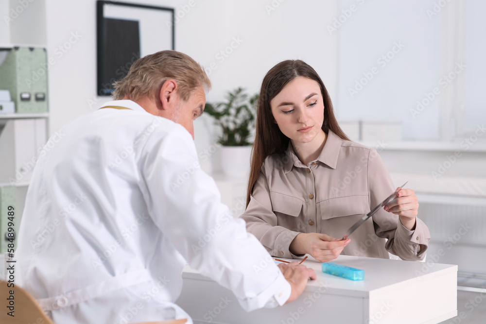 Obraz premium Professional orthopedist consulting patient at table in clinic