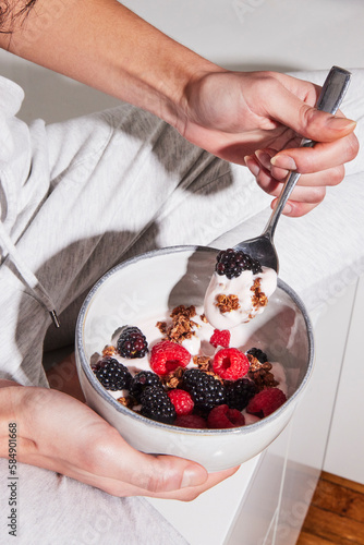 Anonymous woman having a bowl of yogurt with berries