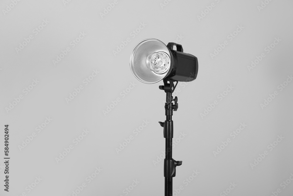 Flashlight with reflector on grey background, space for text. Professional photographer's equipment Flashlight with reflector on grey background, space for text. Professional photographer's equipment