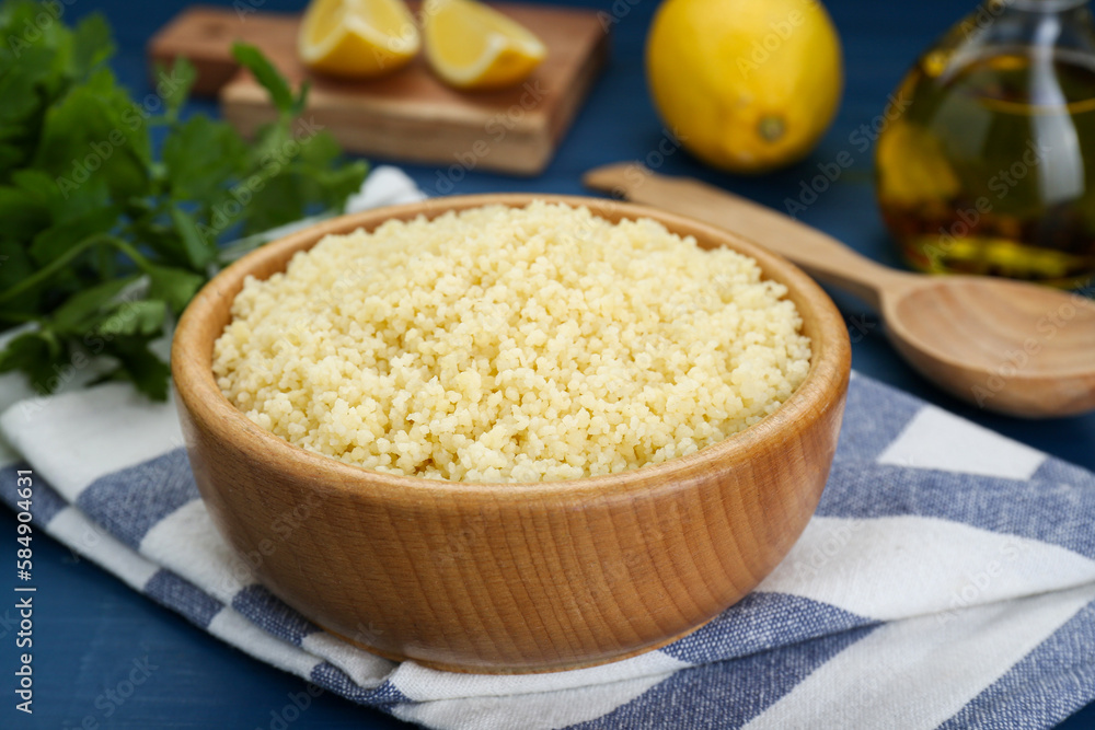 Bowl of tasty couscous on blue wooden table, closeup Bowl of tasty couscous on blue wooden table, closeup
