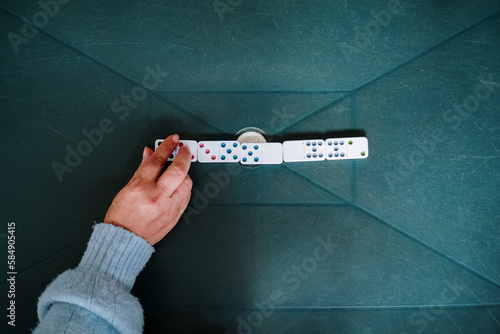 Woman's hand placing a domino tile photo