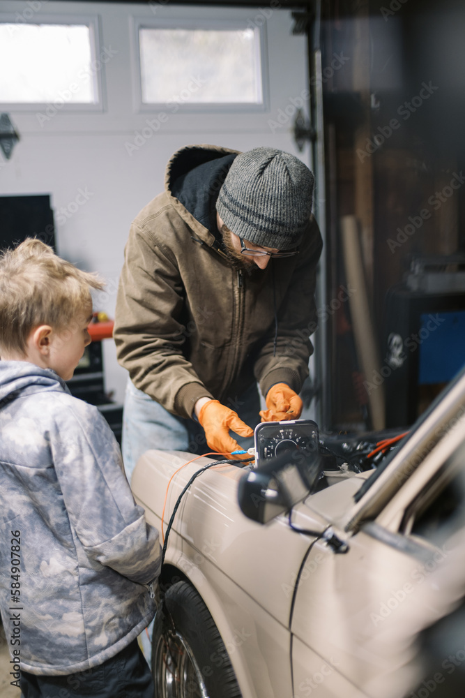 Father and son working on an old car Father and son working on an old car