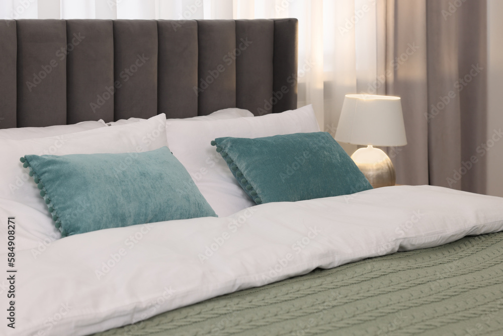 Comfortable bed with bedding and lamp in room Comfortable bed with bedding and lamp in room