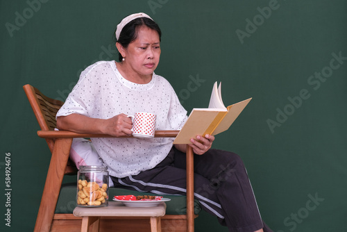 Woman holding a mug while reading. photo