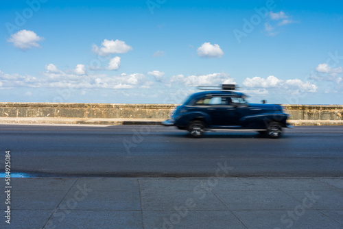 Antique Black Car Driving On A Malecon Highway photo