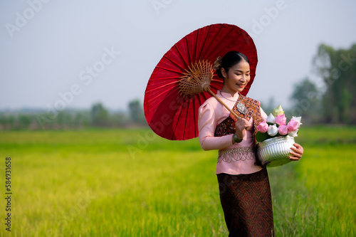Pretty Asian women in traditional Thai dress. Beautiful traditional Thai dresses by Asian Buddhists make merit at the Temple a tourist attraction, a