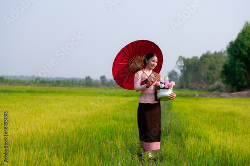 Pretty Asian women in traditional Thai dress. Beautiful traditional Thai dresses by Asian Buddhists make merit at the Temple a tourist attraction, a