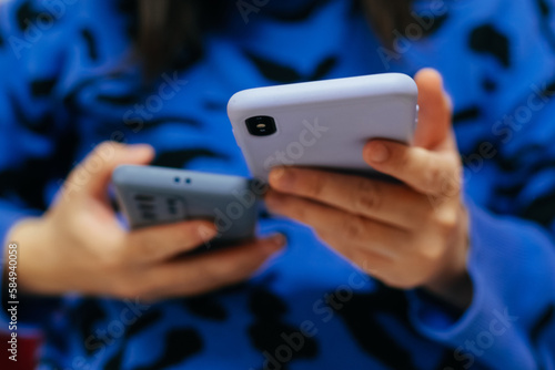 woman using two mobile phone at home photo