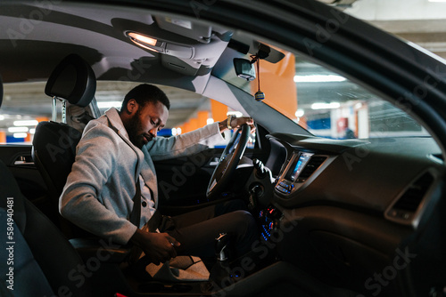 Black male driver taking handbrake off