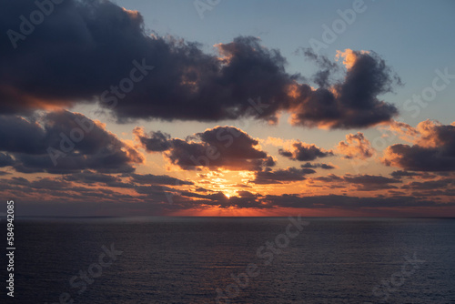 dark blue sea water surface and dramatic orange sky at sunset