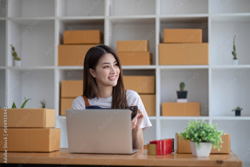 Starting Small business entrepreneur SME freelance, Portrait young woman working at home office, BOX, smartphone, laptop, online, marketing, packaging, delivery, b2b, SME, e-commerce concept.. Starting Small business entrepreneur SME freelance, Portrait young woman working at home office, BOX, smartphone, laptop, online, marketing, packaging, delivery, b2b, SME, e-commerce concept..
