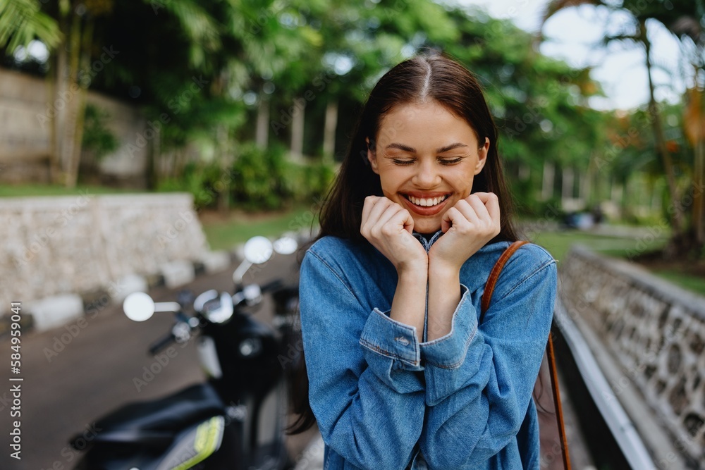 Portrait of a woman brunette smile with teeth walking outside against a backdrop of palm trees in the tropics, summer vacations and outdoor recreation, the carefree lifestyle of a freelance student. Portrait of a woman brunette smile with teeth walking outside against a backdrop of palm trees in the tropics, summer vacations and outdoor recreation, the carefree lifestyle of a freelance student.