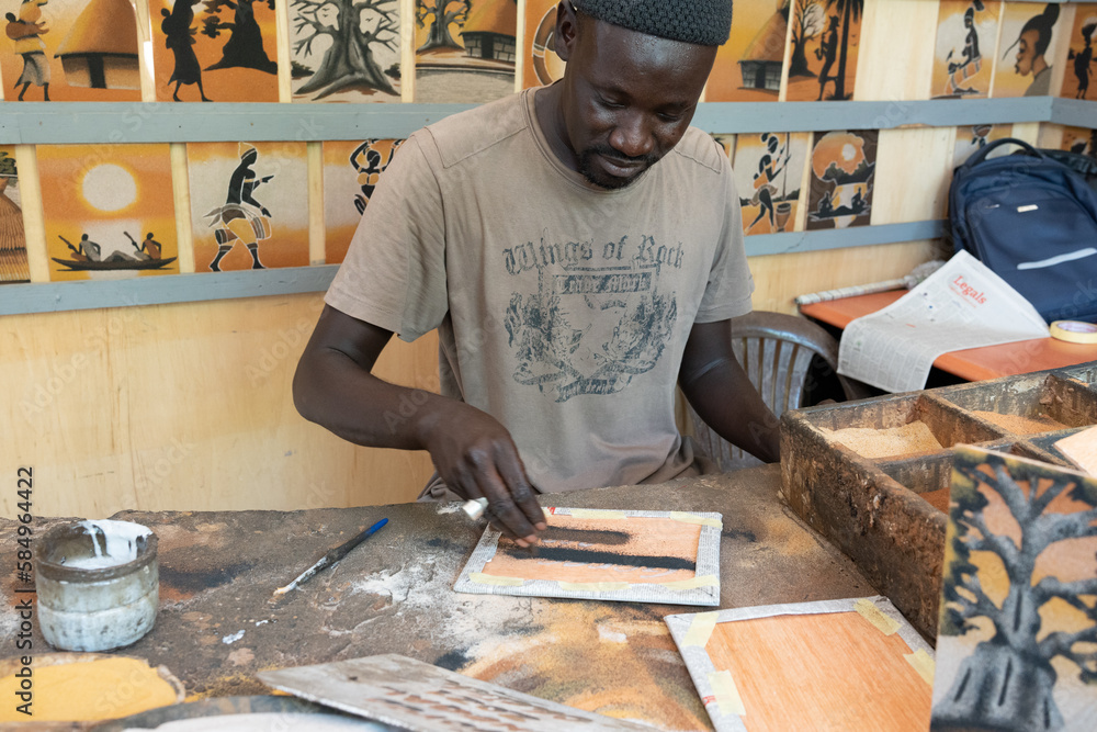 painter artist artisan creating a painting with sand Stock Photo