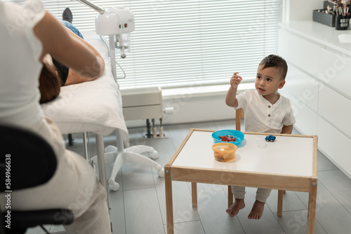 Businesswoman, working in her salon with her son photo