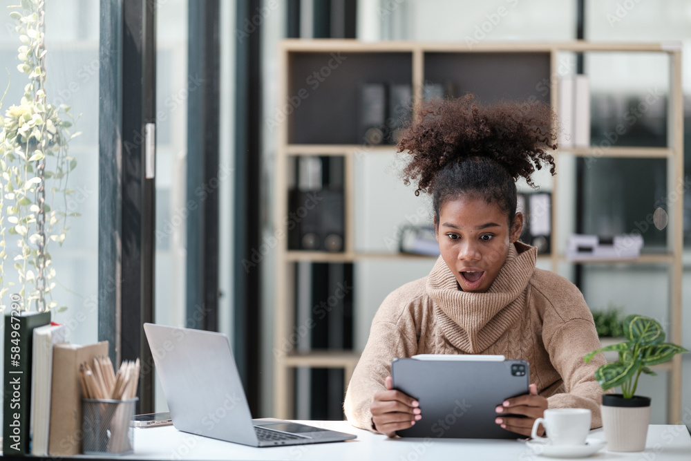American African Woman working in the office with computer phone and Tablet. American African Woman working in the office with computer phone and Tablet.