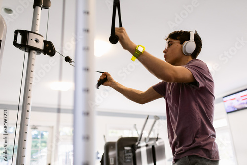Teenage boy bodybuilding in gym photo