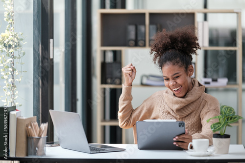 American African Woman working in the office with computer phone and Tablet.