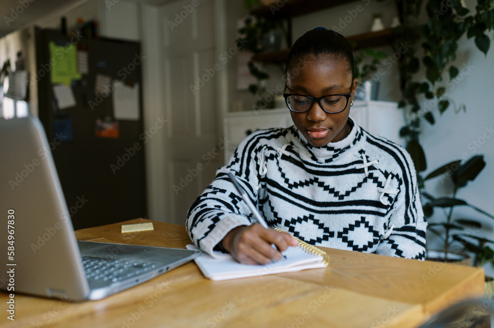 black girl doing homework at table in her home black girl doing homework at table in her home